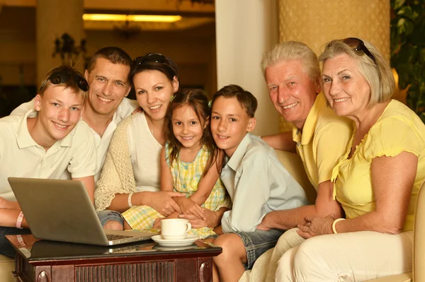 Família sentada com laptop — Fotografia de Stock