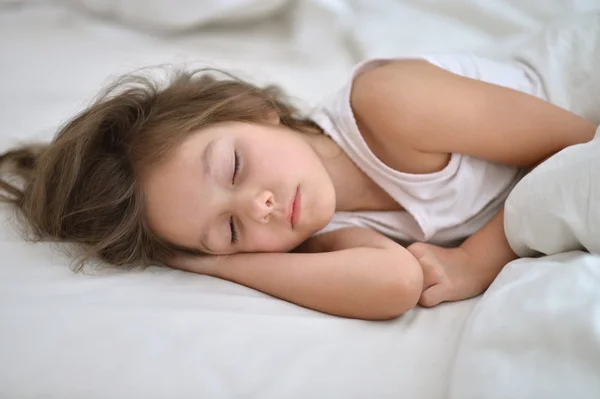 Klein meisje slapen in bed — Stockfoto