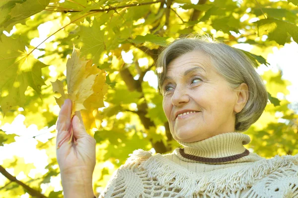 Senior woman in autumn park — Stock Photo, Image