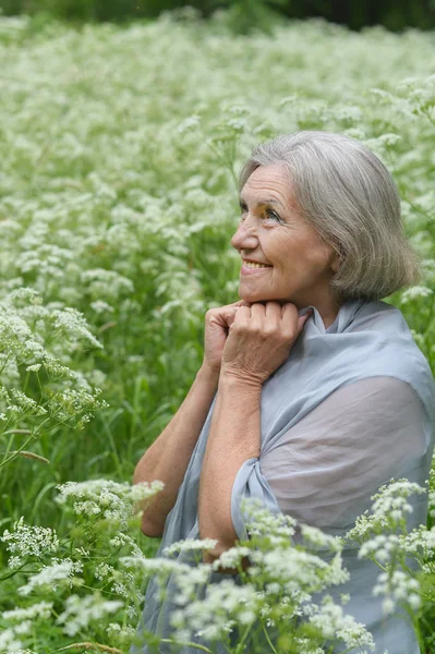 Old woman with white flowers — Stock Photo, Image