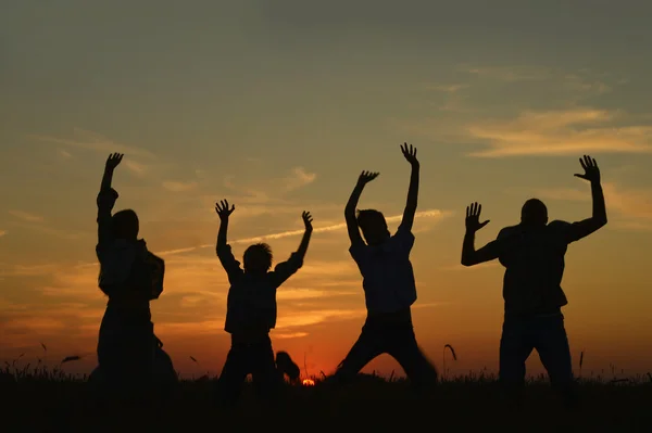 Family jumping in field Stock Photo