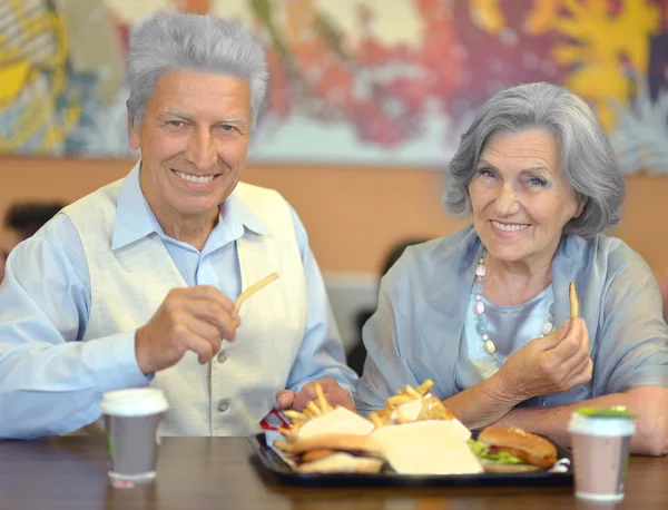 Ouderen paar eten fastfood — Stockfoto