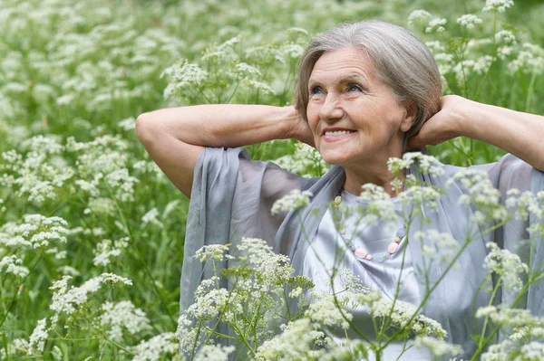 Old woman with white flowers — Stock Photo, Image