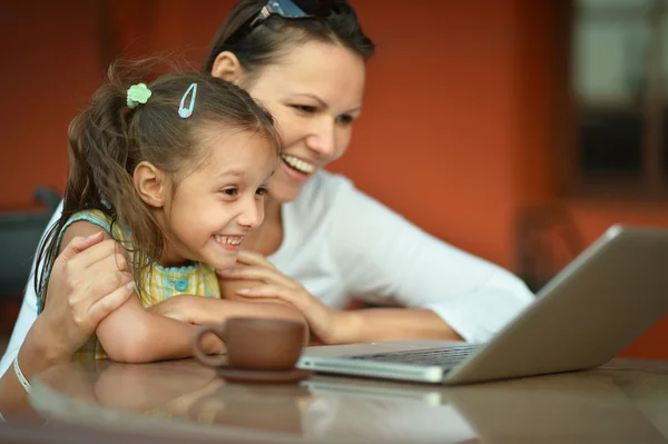 Kvinna med flickan med laptop — Stockfoto