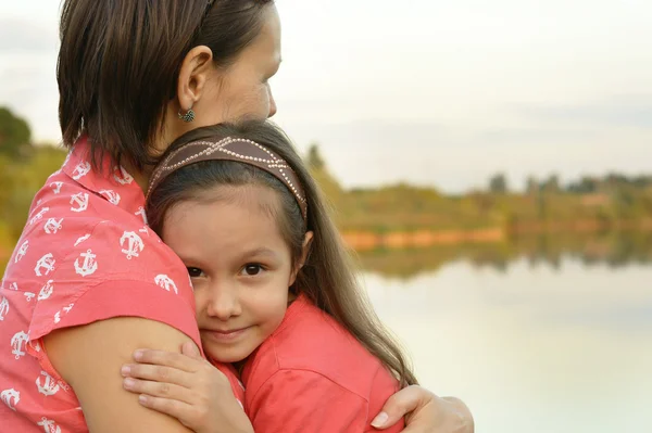 Girl with mother near river — Stock Photo, Image