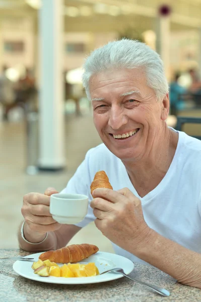 Homme âgé prenant le petit déjeuner — Photo
