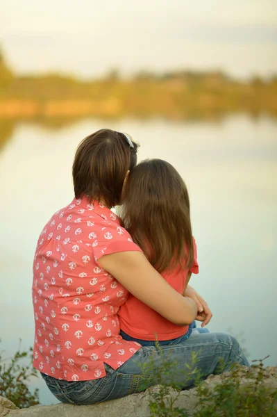 Девочка с матерью у реки — стоковое фото