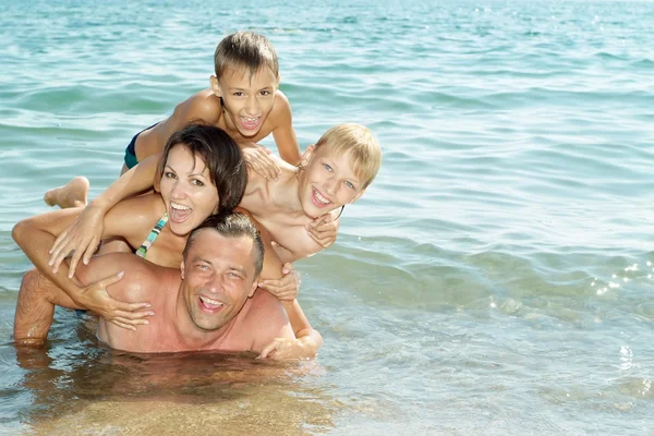 Família feliz na praia — Fotografia de Stock