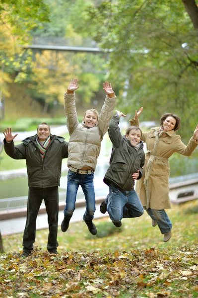 Family jumping in autumn park — Stock Photo, Image