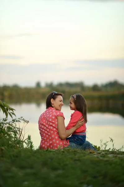 Girl with mother near river — Stock Photo, Image