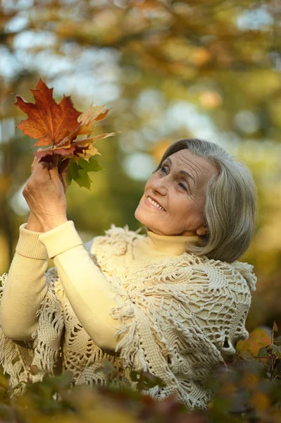 Oudere vrouw in herfstpark — Stockfoto