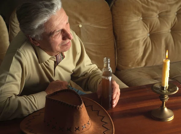 Homme assis à une table avec une bougie — Photo