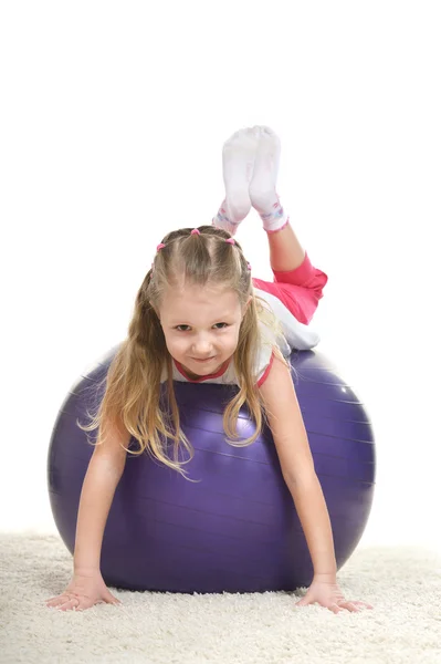 Спортивная маленькая девочка на спортивном мяче — стоковое фото