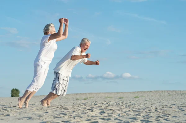 Äldre par avkopplande på stranden — Stockfoto