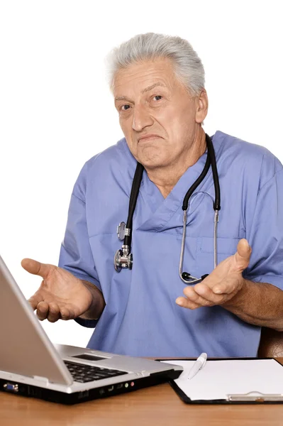 老年医生用一台笔记本电脑 — 图库照片