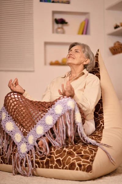 Üst düzey kadın evde meditasyon yapıyor — Stok fotoğraf