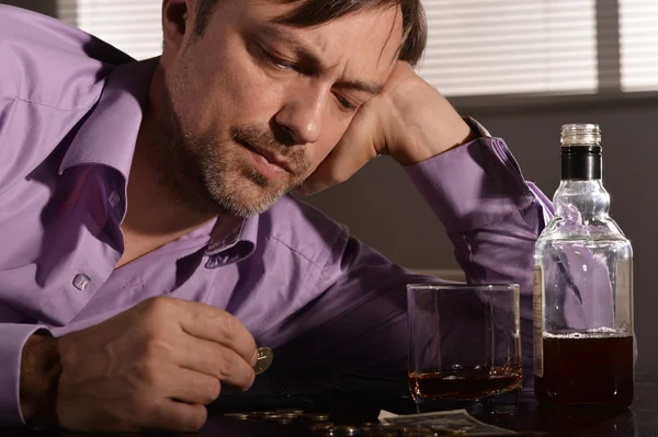 Un homme boit du whisky à table — Photo