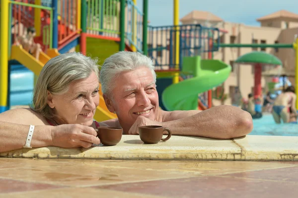 Casal sénior relaxante na piscina — Fotografia de Stock