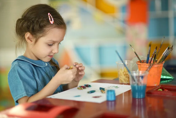 Маленькая девочка рисует красками — стоковое фото
