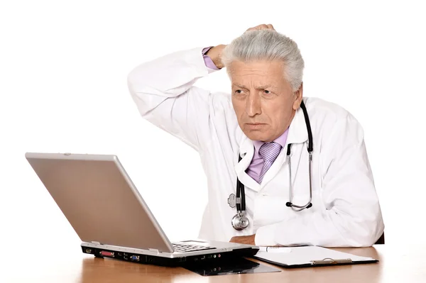 Médico de edad avanzada con un ordenador portátil — Foto de Stock