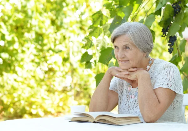 Orta yaşlı bir kadın kitap okumak — Stok fotoğraf