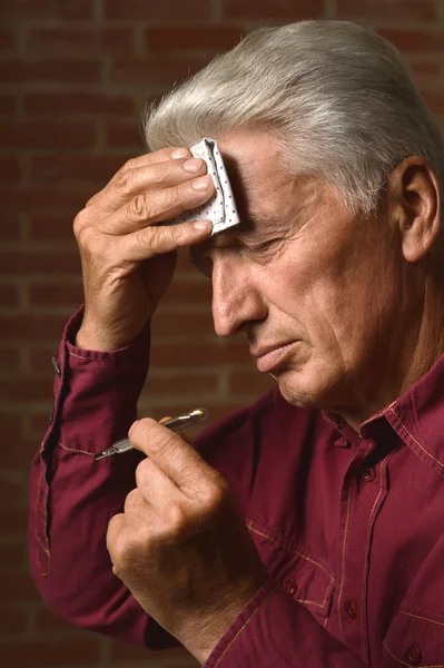 Kranker älterer Mann mit Thermometer — Stockfoto