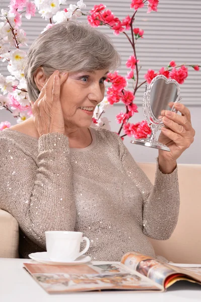 Aged woman  looking in the mirror — Stock Photo, Image