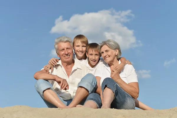 Pojkar med morföräldrar på sand — Stockfoto