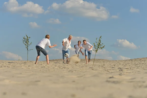 Familj spelar fotboll på stranden — Stock fotografie