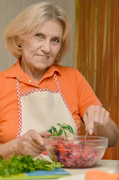 Elderly woman preparing salad — Stock Photo, Image