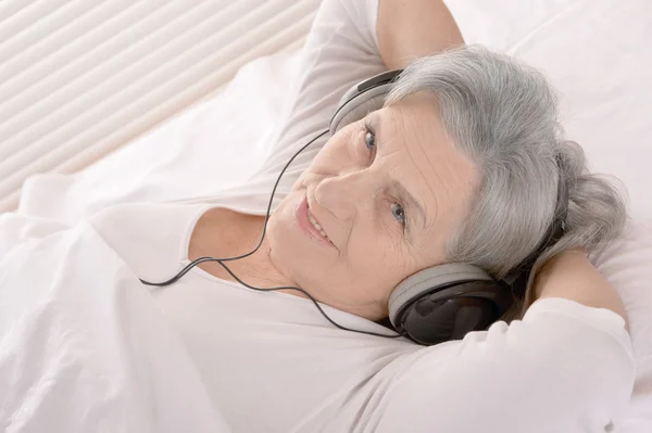 Mulher idosa em fones de ouvido — Fotografia de Stock