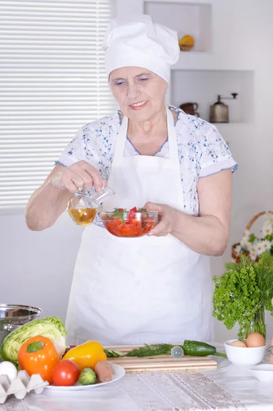 Elderly woman cooking — Stock Photo, Image