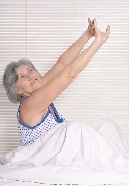 Mulher idosa descansando na cama — Fotografia de Stock