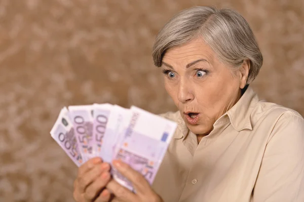 Mujer anciana sosteniendo dinero — Foto de Stock