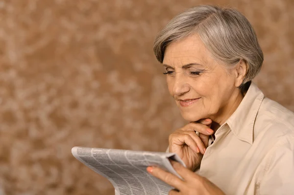 Wieku kobieta czytanie gazety — Zdjęcie stockowe