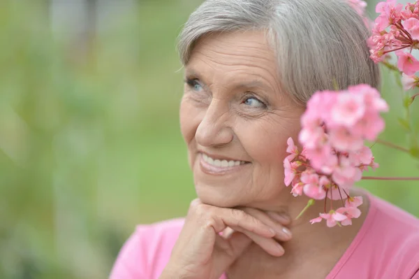 Donna anziana con fiori — Foto Stock