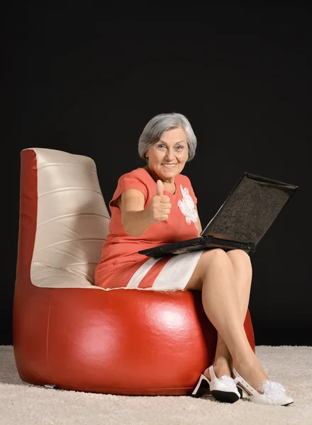 Зрелая женщина расслабляется с ноутбуком — стоковое фото