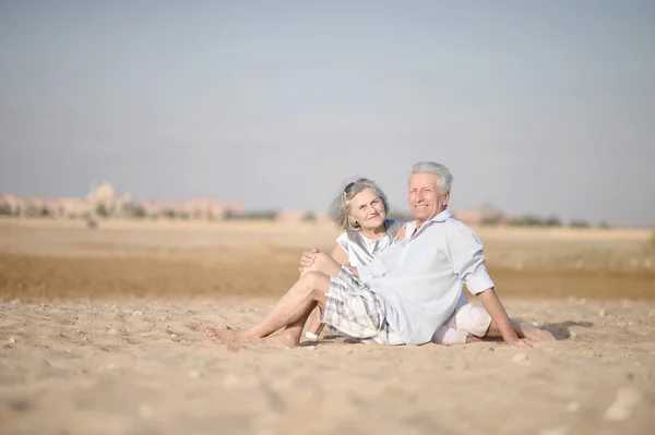 Couple d'âge mûr se détendre sur la plage — Photo