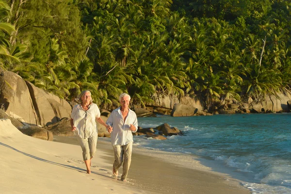 Pareja mayor corriendo en la playa — Foto de Stock