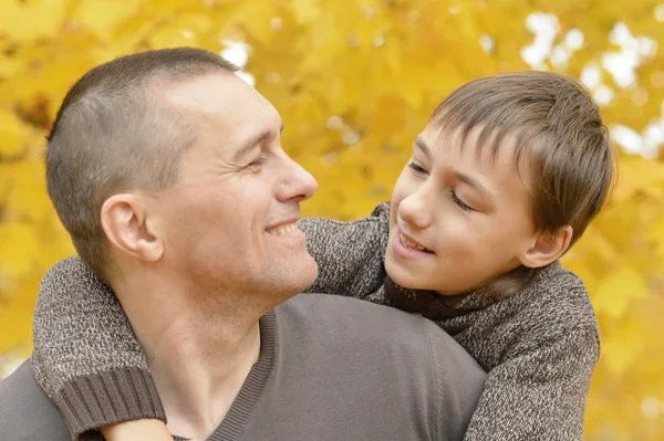 Vader en zoon in herfst park — Stockfoto