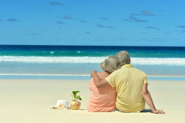 Couple âgé assis sur le rivage — Photo