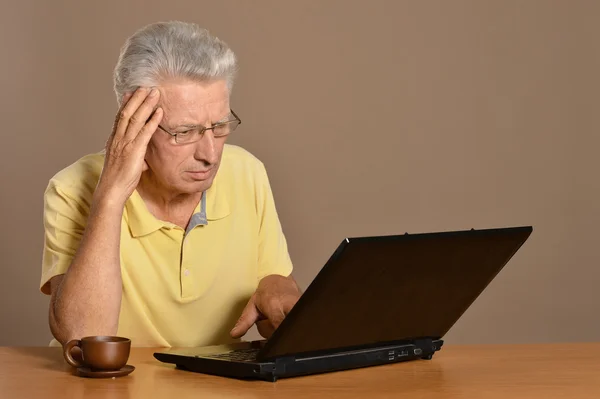 Homem sênior sentado com laptop — Fotografia de Stock