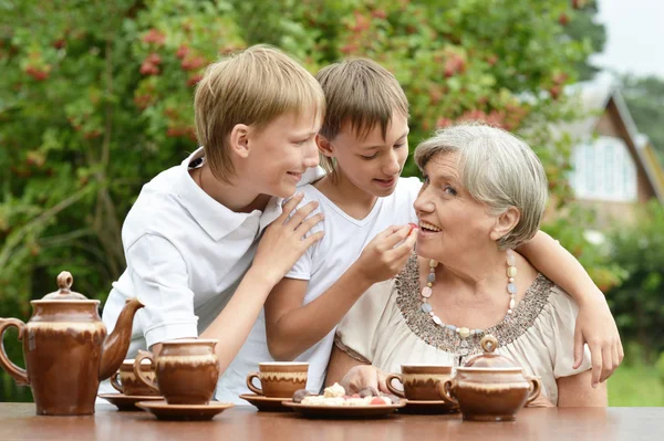 Семья пьет чай в саду — стоковое фото