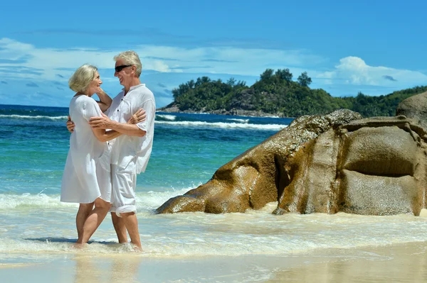 Casal de idosos em pé na praia — Fotografia de Stock