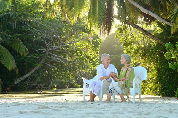 Casal de idosos sentado na praia — Fotografia de Stock