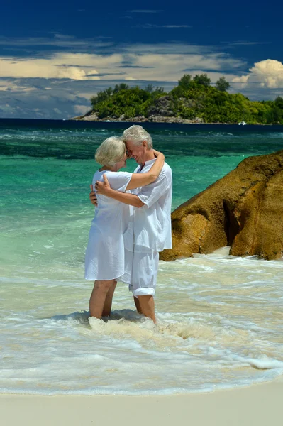 Bejaarde echtpaar staande op strand — Stockfoto