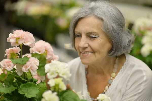 Older woman with flowers — Stock Photo, Image