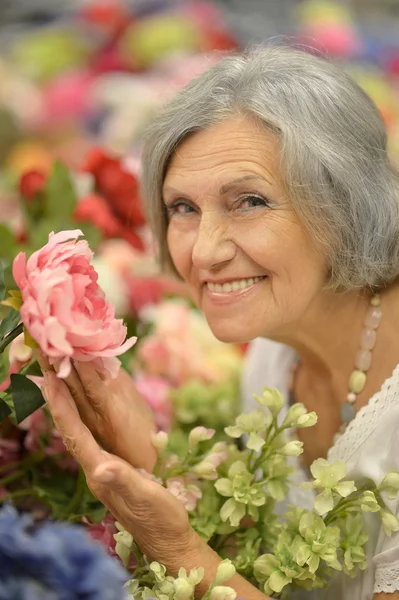 Older woman with flowers — Stock Photo, Image