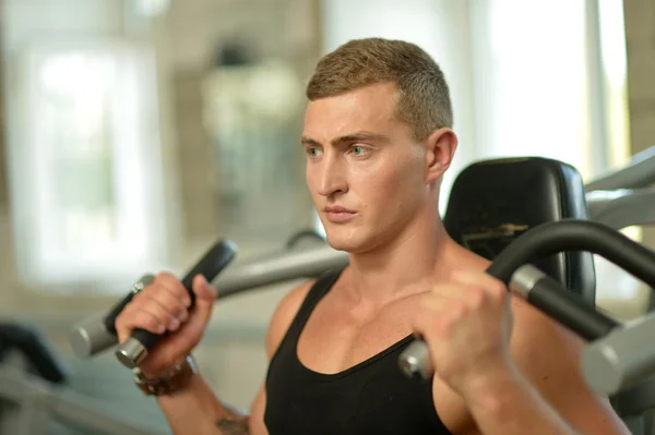 Jeune homme exercices dans la salle de gym — Photo