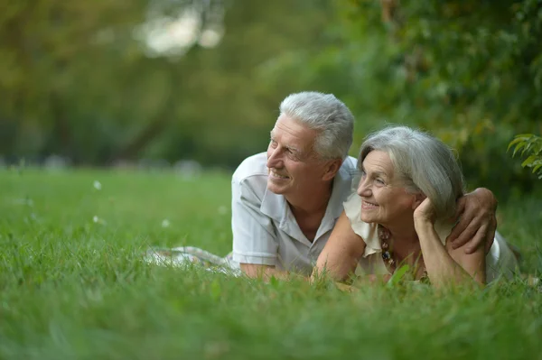 Ouder paar liggen in park — Stockfoto